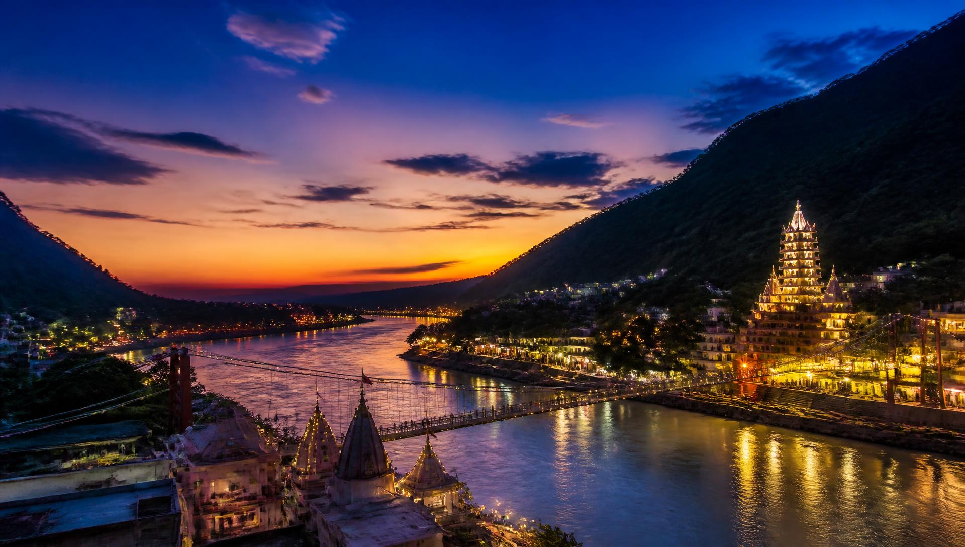 Dusk over the Ganges at Rishikesh with lit temple spires